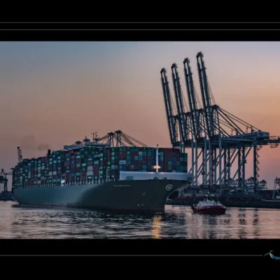 Photo de cargo au coucher du soleil – transport maritime et logistique portuaire. Découvrez l’univers du commerce international à travers une image de porte-conteneurs chargé, naviguant dans un port moderne. Idéal pour illustrer les infrastructures portuaires, la chaîne logistique mondiale et les métiers de la mer. Ordigraph