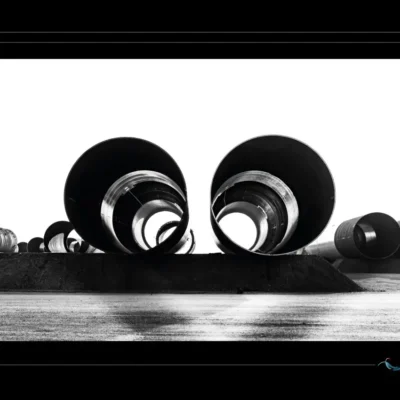 Photo industrielle en noir et blanc avec deux tuyaux métalliques symétriques, ambiance minimaliste et géométrique. Idéal pour illustrer des chantiers techniques, infrastructures lourdes ou compositions abstraites. Perspective frontale, contraste élevé. Ordigraph