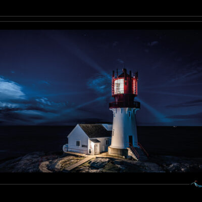 Photo nocturne du phare de Lindesnes en Norvège, paysage côtier avec mer calme, ciel étoilé, lumière de phare, maison éclairée et rochers. Image scandinave haute définition, ambiance maritime, solitude nordique et architecture emblématique. Idéal pour blog de voyage, site photo, inspiration nordique et récits visuels. Ordigraph
