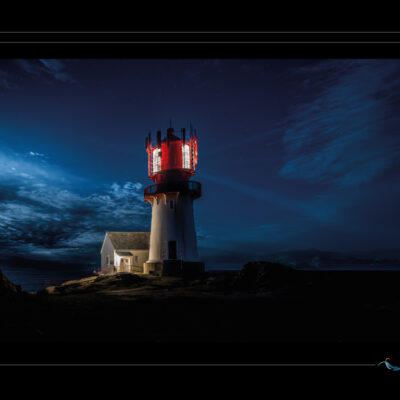 Photo nocturne du phare de Lindesnes en Norvège, paysage côtier avec mer calme, ciel étoilé, lumière de phare, maison éclairée et rochers. Image scandinave haute définition, ambiance maritime, solitude nordique et architecture emblématique. Idéal pour blog de voyage, site photo, inspiration nordique et récits visuels. Ordigraph