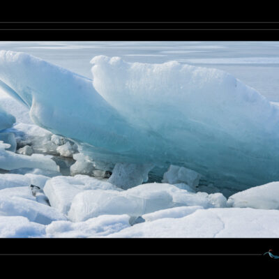 Photo de paysage glacé avec formations de glace bleue, fragments gelés, textures naturelles et ambiance polaire. Image haute définition, idéale pour blog de voyage, site photo, inspiration arctique, glaciologie et récits visuels. Ordigraph